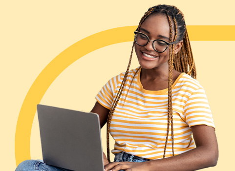 girl in yellow striped tshirt using silver laptop on orange background.