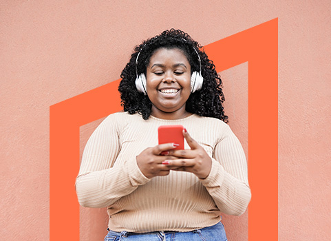 Girl in headphones smiling at smartphone.