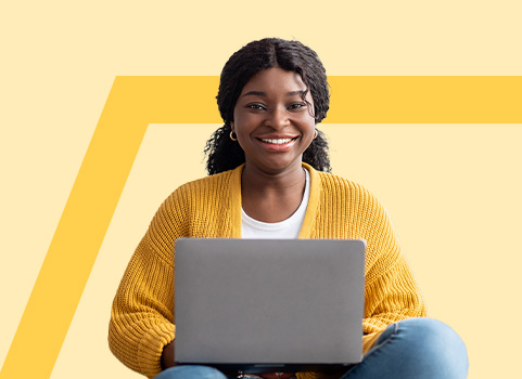 Girl in yellow sweater using silver laptop.