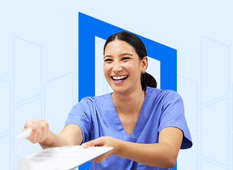 A woman with medium skintone and dark hair, wearing scrubs and holding out a clipboard and a pen, demonstrating medical assistant duties